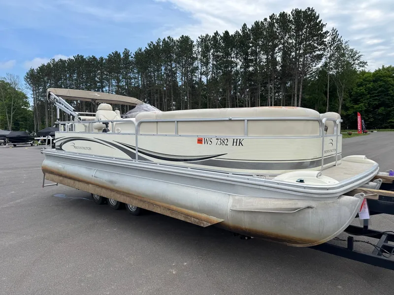 Slide: The Image of A 2008 Bennington 2275RL SPS TRI pontoon boat on a trailer, surrounded by trees. - 3