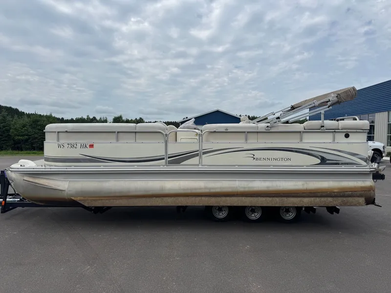Slide: The Image of A 2008 Bennington 2275RL SPS TRI pontoon boat on a trailer, parked near a building. - 6