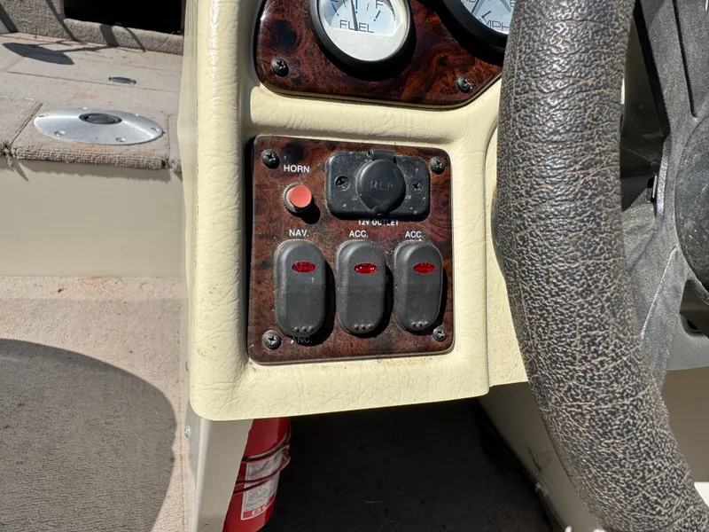Slide: The Image of Close-up of a boat's dashboard with switches and a steering wheel. - 20