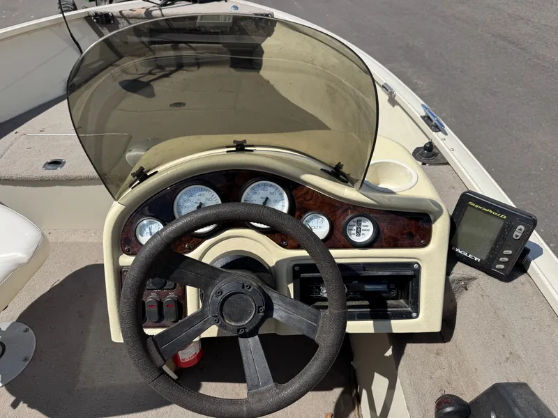 Slide: The Image of The image shows a boat's cockpit with a steering wheel, gauges, and a fish finder. - 19
