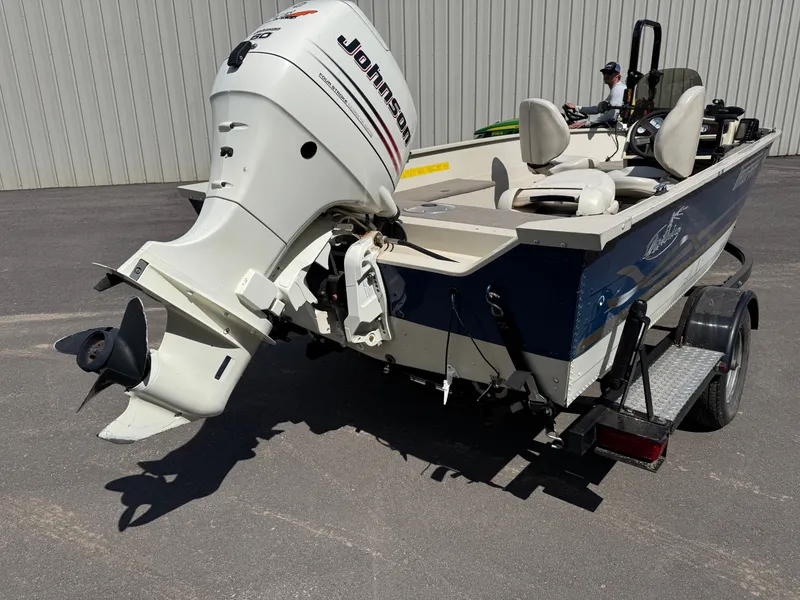 Slide: The Image of A 2002 Misty Harbor 166C Trophy boat on a trailer, featuring a Johnson outboard motor. - 6