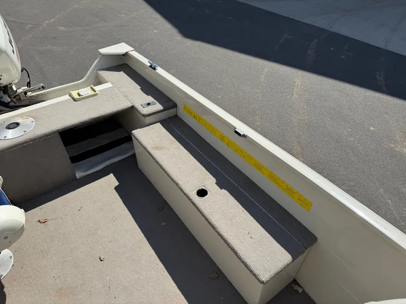 Slide: The Image of The image shows the interior of a boat with gray seating and a motor. - 16