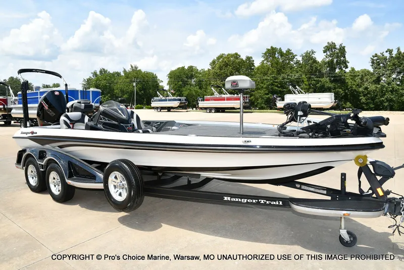 The Image of A 2021 Ranger Z521L CUP boat on a trailer, parked on a concrete lot. - 1
