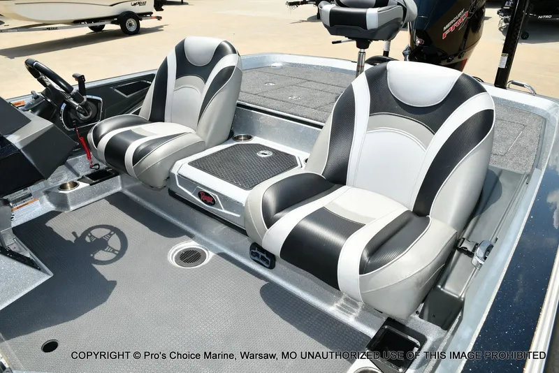 Slide: The Image of Two padded seats in a modern boat, featuring a gray floor and steering console. - 23