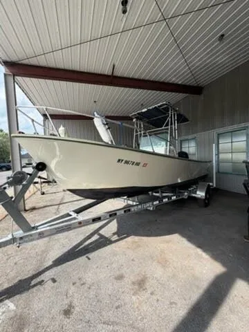 The Image of A 1974 Aquasport WT20 boat on a trailer under a covered area. - 1
