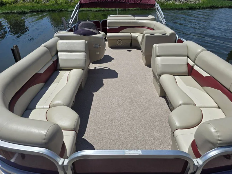 Slide: The Image of A 2016 Misty Harbor 245CR pontoon boat with beige and red seating on calm water. - 3