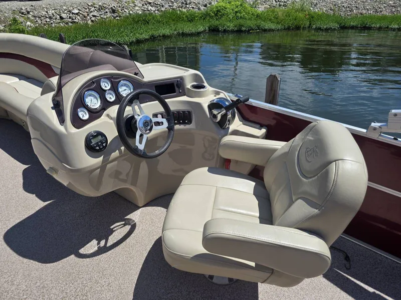 Slide: The Image of The image shows the cockpit of a 2016 Misty Harbor 245CR boat with beige seating and dashboard. - 8