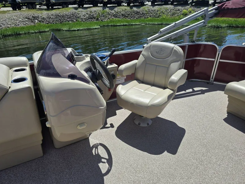 Slide: The Image of A 2016 Misty Harbor 245CR with a beige captain's chair and helm by the water. - 7