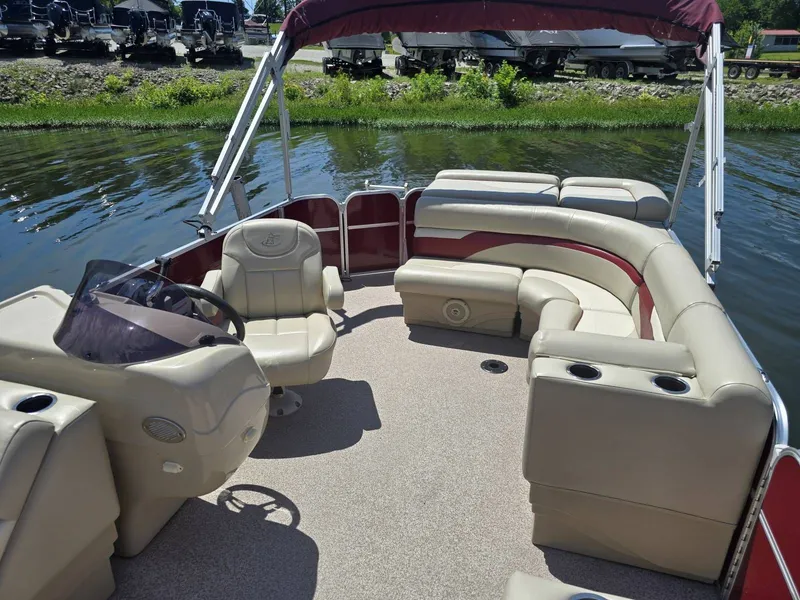 Slide: The Image of A 2016 Misty Harbor 245CR pontoon boat with beige seating and red accents on calm water. - 11
