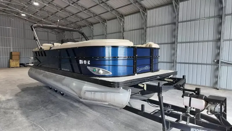 Slide: The Image of A 2019 Silver Wave 230 Island CLS pontoon boat is parked in a covered storage area. - 18