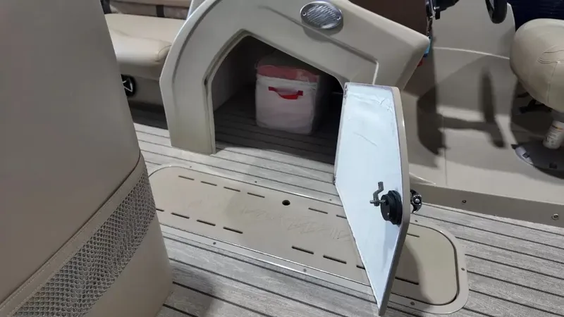 Slide: The Image of An open storage compartment on a boat with wooden flooring and beige interior. - 37