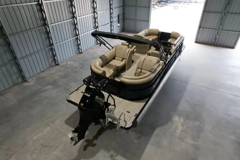 Slide: The Image of A 2019 Silver Wave 230 Island CLS pontoon boat in a warehouse, featuring beige seating and a Suzuki engine. - 4