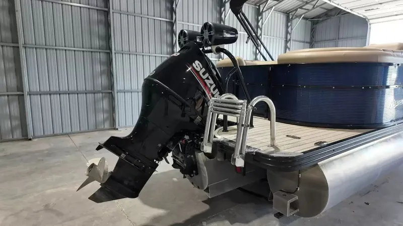 Slide: The Image of A 2019 Silver Wave 230 Island CLS pontoon boat with a Suzuki outboard motor in a storage shed. - 8