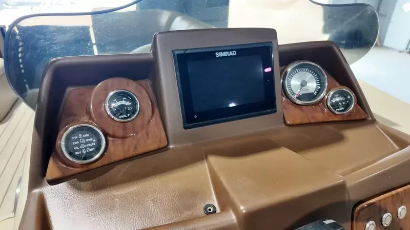 Slide: The Image of The dashboard of a 2019 Silver Wave 230 Island CLS with a Simrad screen and gauges. - 41