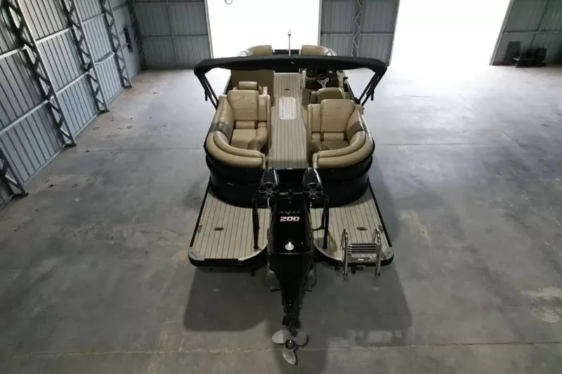 Slide: The Image of A 2019 Silver Wave 230 Island CLS in a warehouse. It features beige seating and an outboard motor. - 7