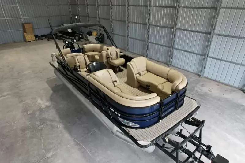 Slide: The Image of A 2019 Silver Wave 230 Island CLS pontoon boat in a storage facility. It features beige seating. - 19