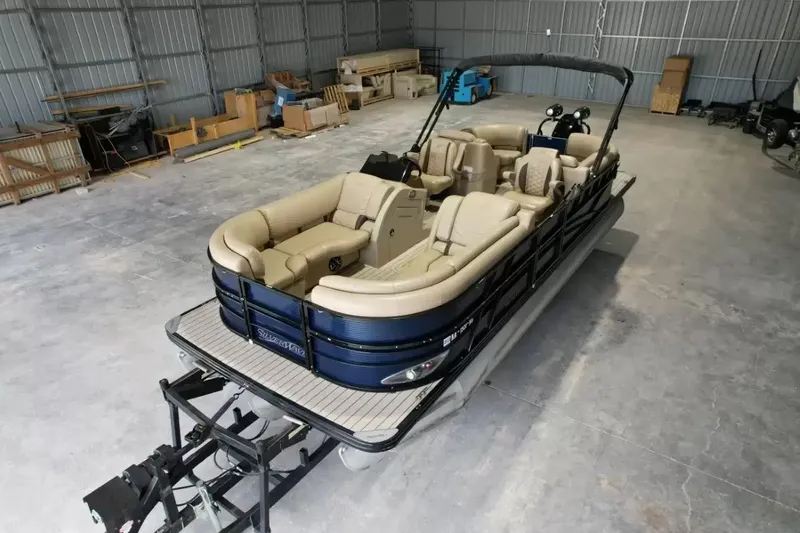 Slide: The Image of A 2019 Silver Wave 230 Island CLS pontoon boat in a warehouse, featuring beige seating and black railing. - 15