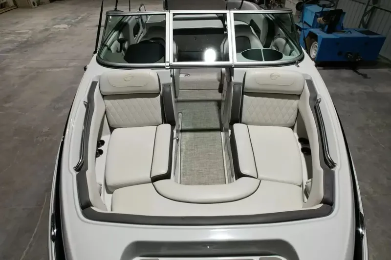 Slide: The Image of The image shows the cockpit of a 2021 Crownline Eclipse E215 XS boat with beige upholstery. - 24