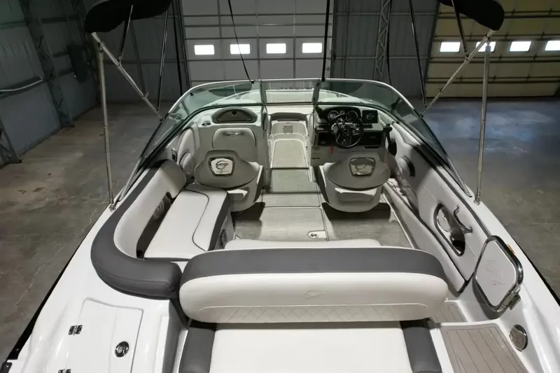 Slide: The Image of The image shows the interior of a 2021 Crownline Eclipse E215 XS boat with gray and white seating. - 39
