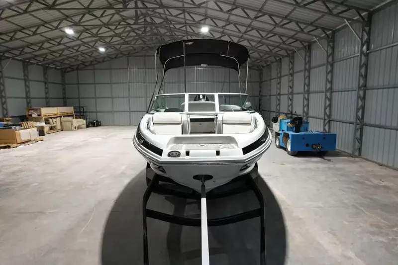 Slide: The Image of A 2021 Crownline Eclipse E215 XS boat is in a large warehouse. - 13