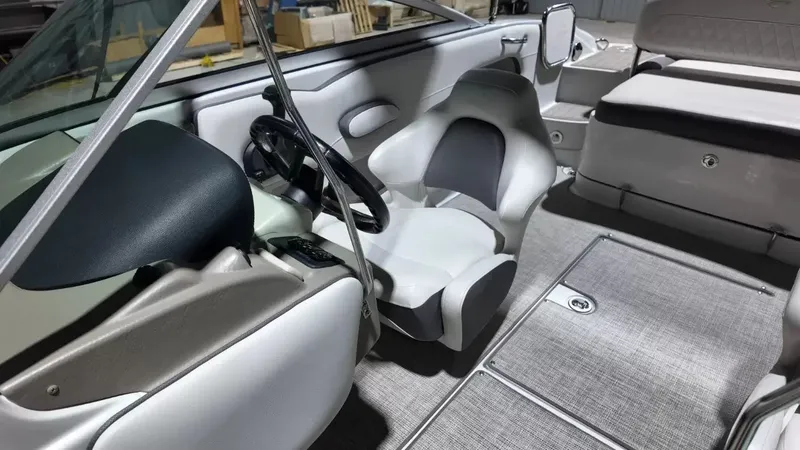 Slide: The Image of Interior of a 2021 Crownline Eclipse E215 XS with gray seating and carpeted flooring. - 29