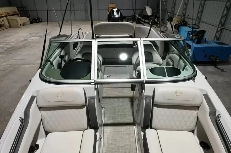 Slide: The Image of The image shows the cockpit of a 2021 Crownline Eclipse E215 XS boat with white seating. - 26