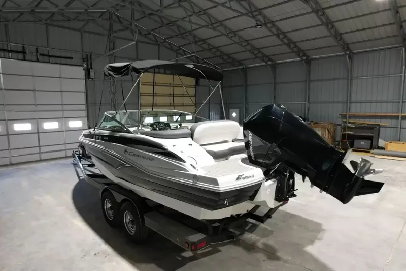 Slide: The Image of A 2021 Crownline Eclipse E215 XS boat is on a trailer inside a warehouse. - 9