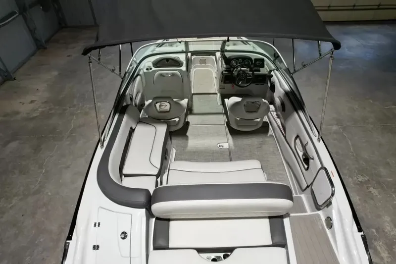 Slide: The Image of The image shows the interior of a 2021 Crownline Eclipse E215 XS boat with gray and white seating. - 43