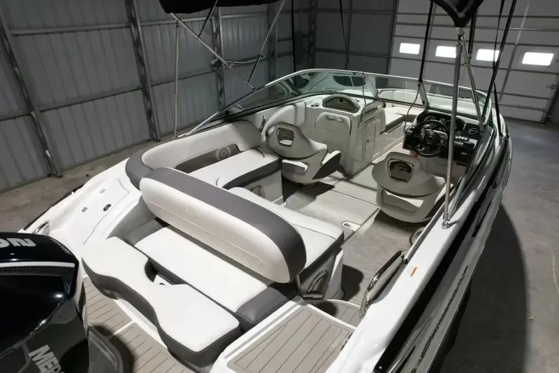 Slide: The Image of The image shows the interior of a 2021 Crownline Eclipse E215 XS boat with gray and white seating. - 44