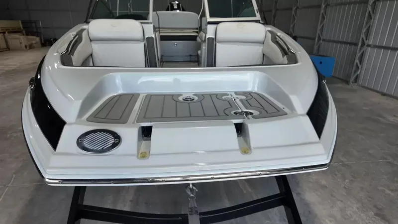 Slide: The Image of The image shows the stern of a 2021 Crownline Eclipse E215 XS boat in a storage facility. - 16