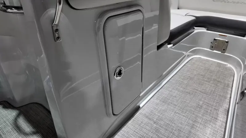 Slide: The Image of The image shows the interior of a 2021 Crownline Eclipse E215 XS boat with gray flooring. - 27