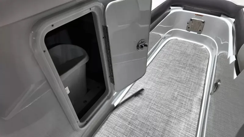 Slide: The Image of The image shows the interior of a 2021 Crownline Eclipse E215 XS boat with a small door and storage space. - 28
