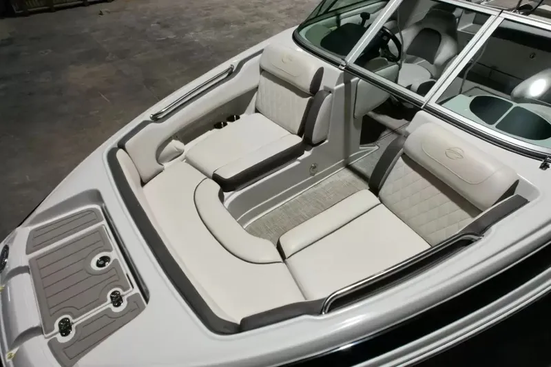 Slide: The Image of The image shows the cockpit of a 2021 Crownline Eclipse E215 XS with beige upholstery. - 20