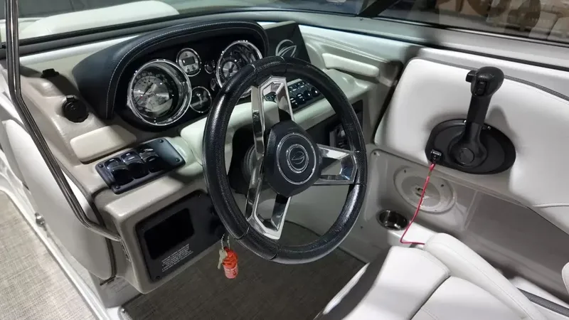 Slide: The Image of The image shows the cockpit of a 2021 Crownline Eclipse E215 XS with a sleek steering wheel and instruments. - 31