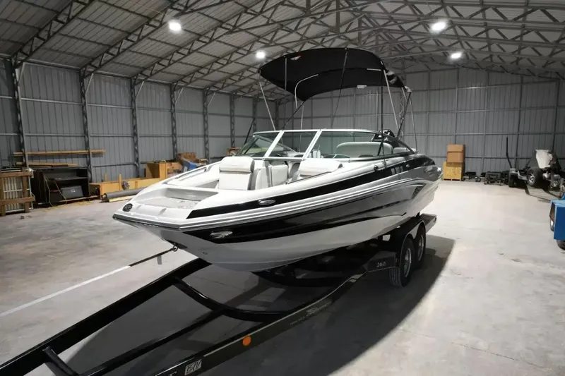 Slide: The Image of 2021 Crownline Eclipse E215 XS on a trailer in a storage facility. - 11