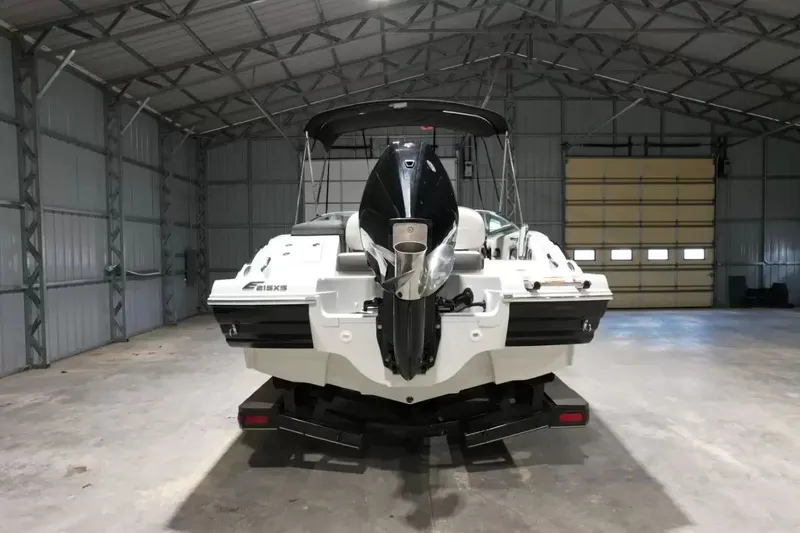 Slide: The Image of A 2021 Crownline Eclipse E215 XS boat is parked in a large warehouse. - 7