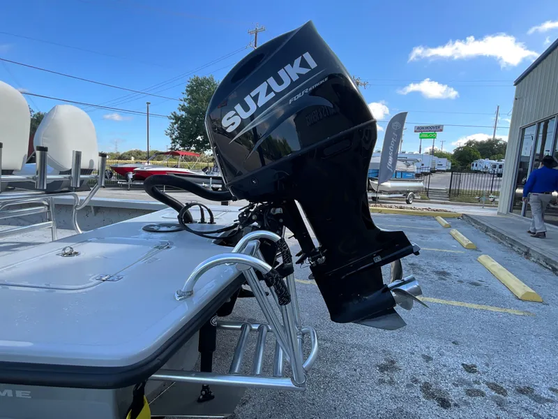 Slide: The Image of A Majek 20 Xtreme boat with a Suzuki outboard motor, parked in a lot. - 6
