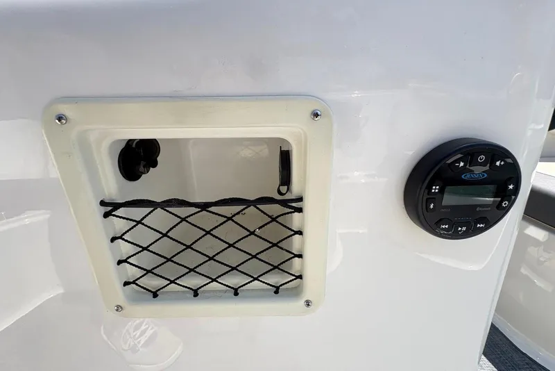 Slide: The Image of 2023 Bayliner Element E18 boat dashboard with storage compartment and Jensen audio system. - 4