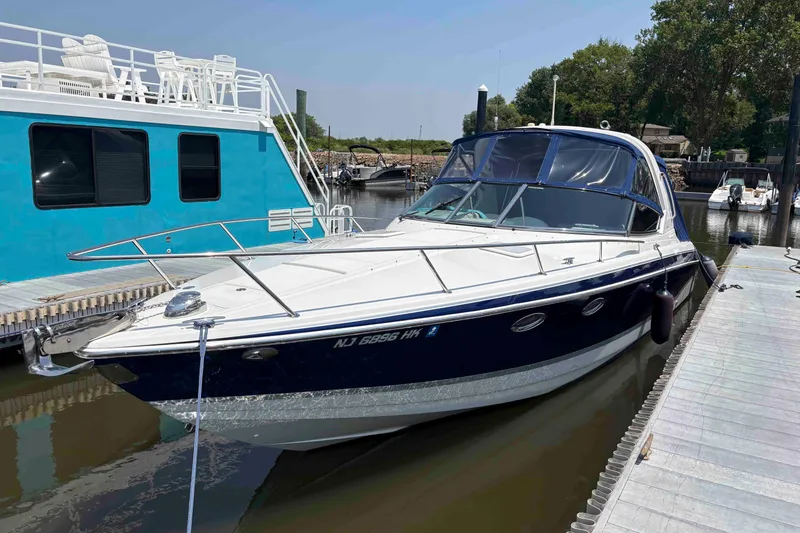 The Image of 2007 Formula 330 Sun Sport boat docked beside a blue houseboat. - 0
