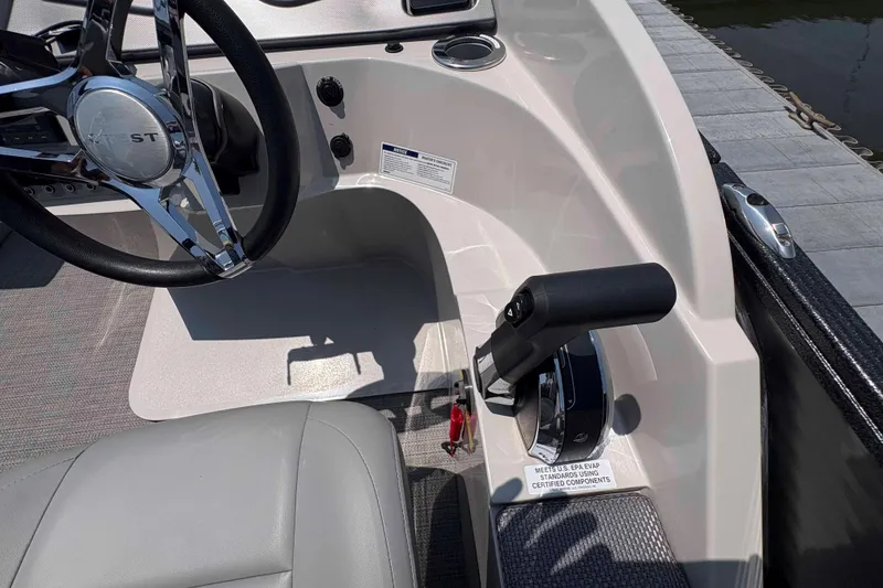 Slide: The Image of 2023 Crest Classic DLX 220 boat helm with steering wheel and throttle controls. - 18