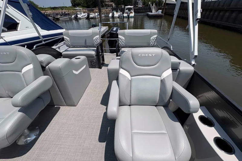 Slide: The Image of 2023 Crest Classic DLX 220 boat interior with luxurious gray seating and cup holders. - 2