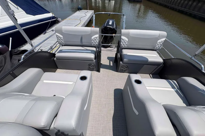 Slide: The Image of 2023 Crest Classic DLX 220 pontoon boat interior with gray seating and cup holders. - 4