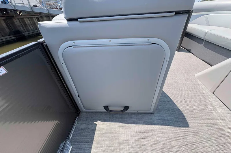 Slide: The Image of 2023 Crest Classic DLX 220 boat interior with storage compartment and seating area. - 23