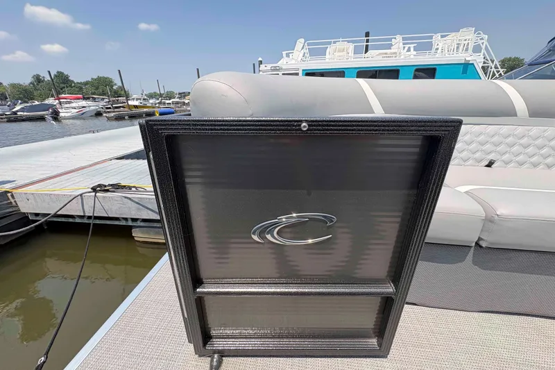 Slide: The Image of 2023 Crest Classic DLX 220 pontoon boat at marina, featuring sleek design and comfortable seating. - 6