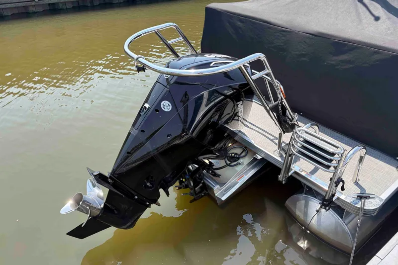 Slide: The Image of 2023 Crest Classic DLX 220 boat engine and ladder on water. - 3
