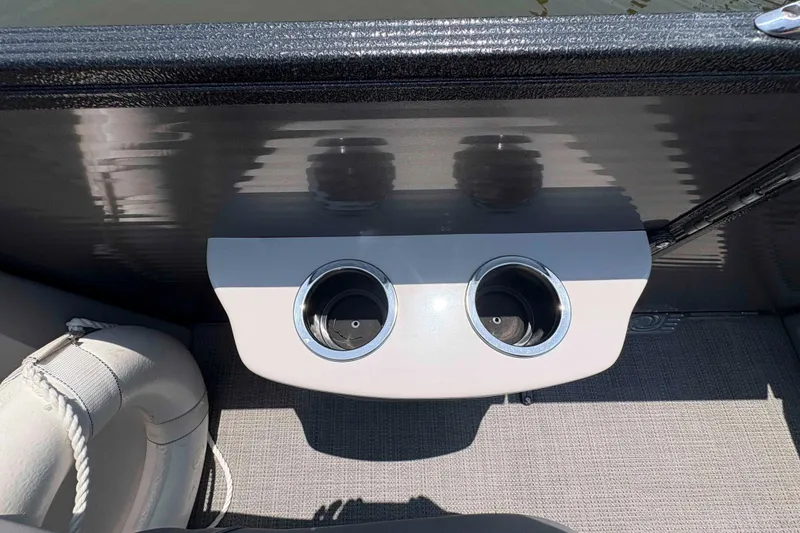 Slide: The Image of 2023 Crest Classic DLX 220 boat interior with dual cup holders and cushioned seating. - 22