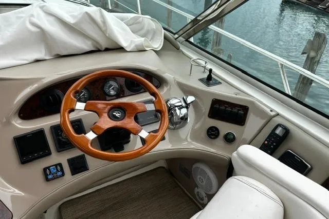 Slide: The Image of 2003 Sea Ray 550 Sundancer helm with wooden steering wheel and control panel. - 26