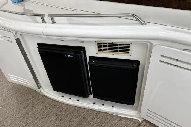 Slide: The Image of 2003 Sea Ray 550 Sundancer yacht interior with built-in mini fridge and storage compartments. - 28