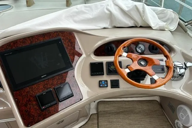 Slide: The Image of Helm of 2003 Sea Ray 550 Sundancer with wood steering wheel and navigation displays. - 27
