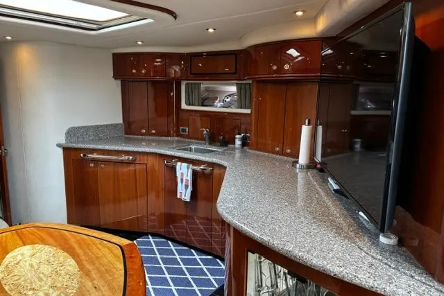 Slide: The Image of Luxurious 2003 Sea Ray 550 Sundancer yacht interior with elegant wood cabinetry and modern amenities. - 2